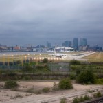 An aircraft lines up ready for take-off at London City. Canary Wharf and the O2 are in the background.